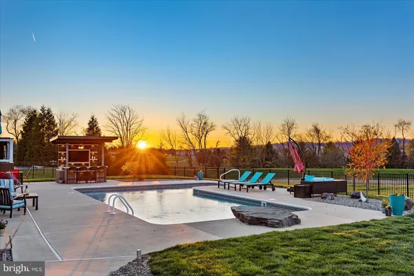 a view of a swimming pool with a patio and a yard