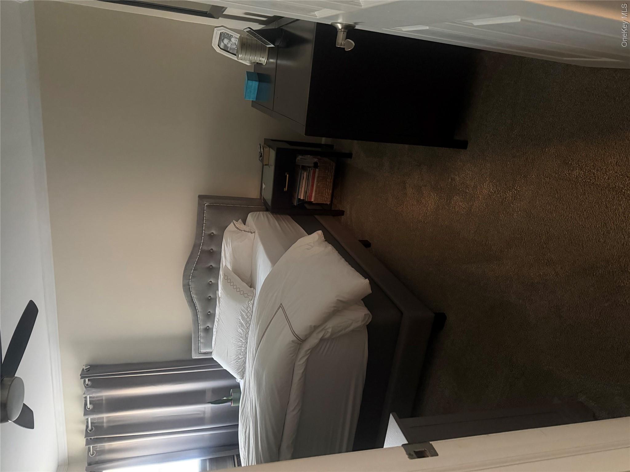 1580 North Jerusalem Road Merrick, NY 11566 - Photo 19 of 36 The property features a bedroom with neutral-toned walls, carpeted flooring, and a ceiling fan