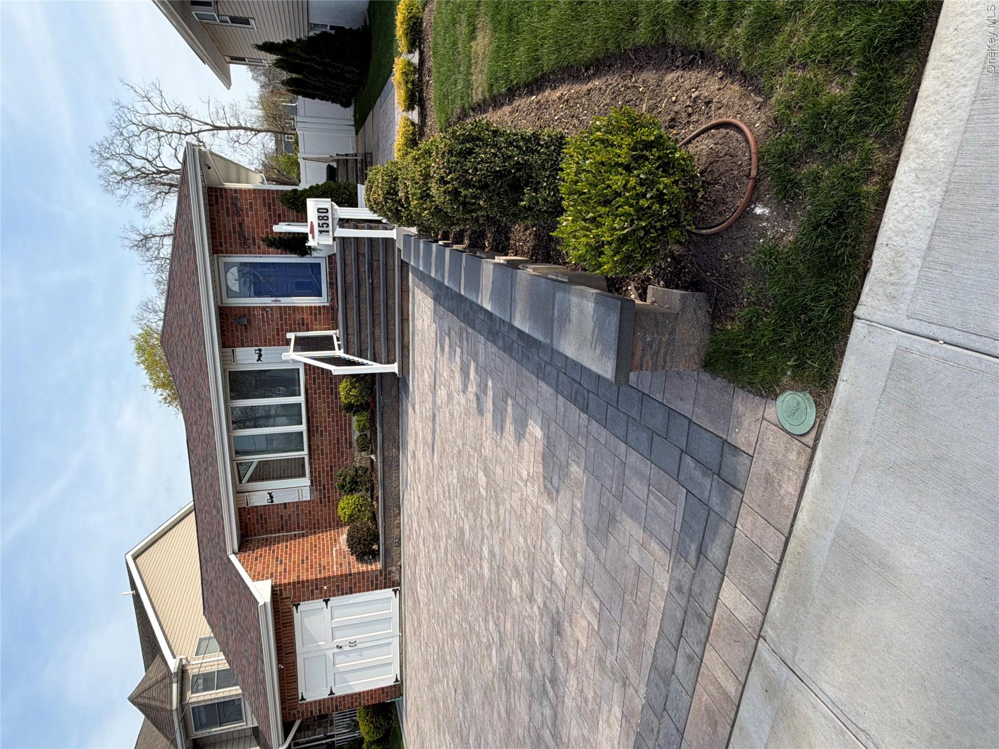 1580 North Jerusalem Road Merrick, NY 11566 - Photo 2 of 36 The property features a brick exterior, an attached garage, and a paver driveway