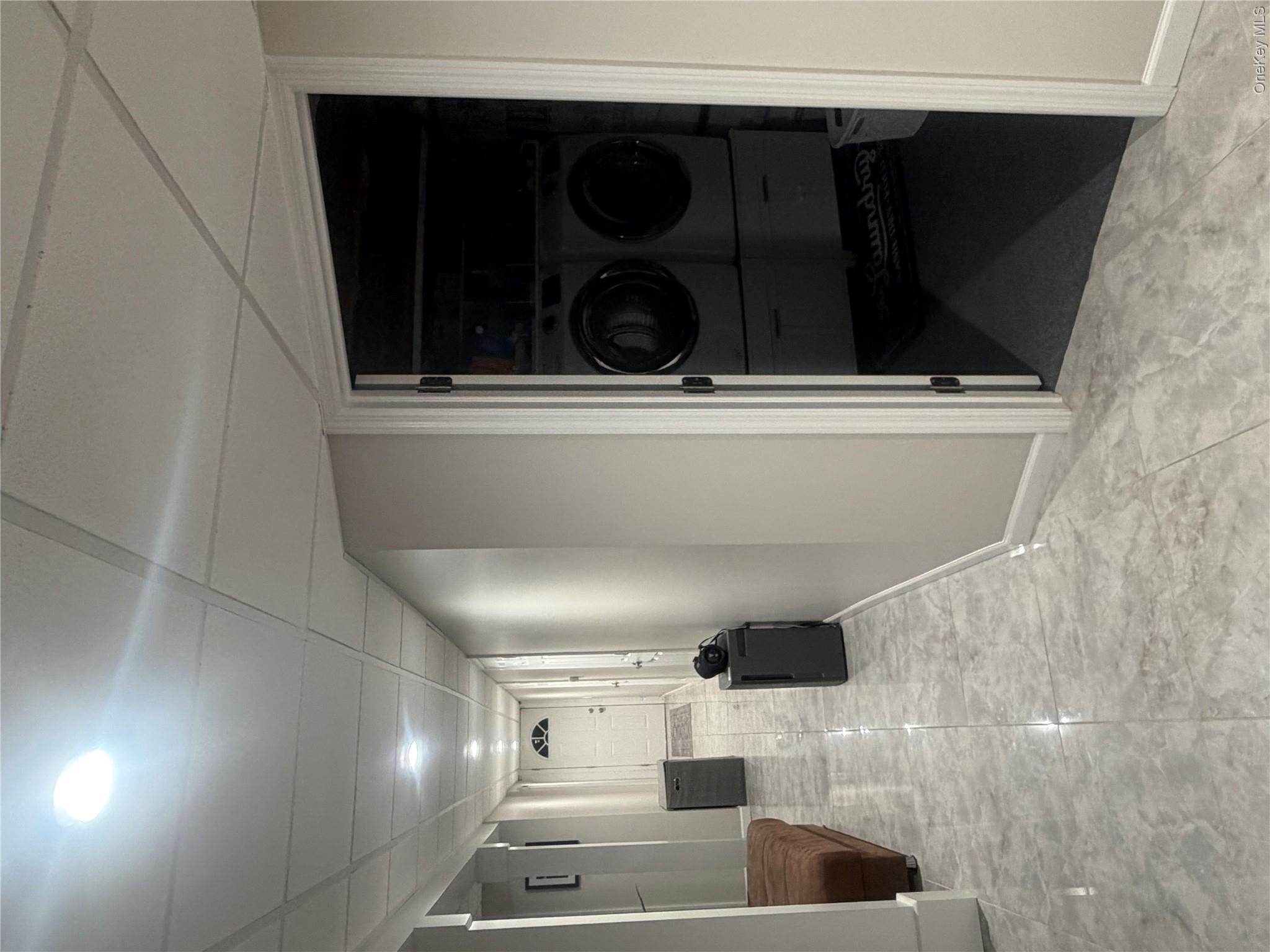 1580 North Jerusalem Road Merrick, NY 11566 - Photo 28 of 36 The property features a dedicated laundry area with a washer and dryer, set within a spacious hallway with marble-style flooring and recessed lighting