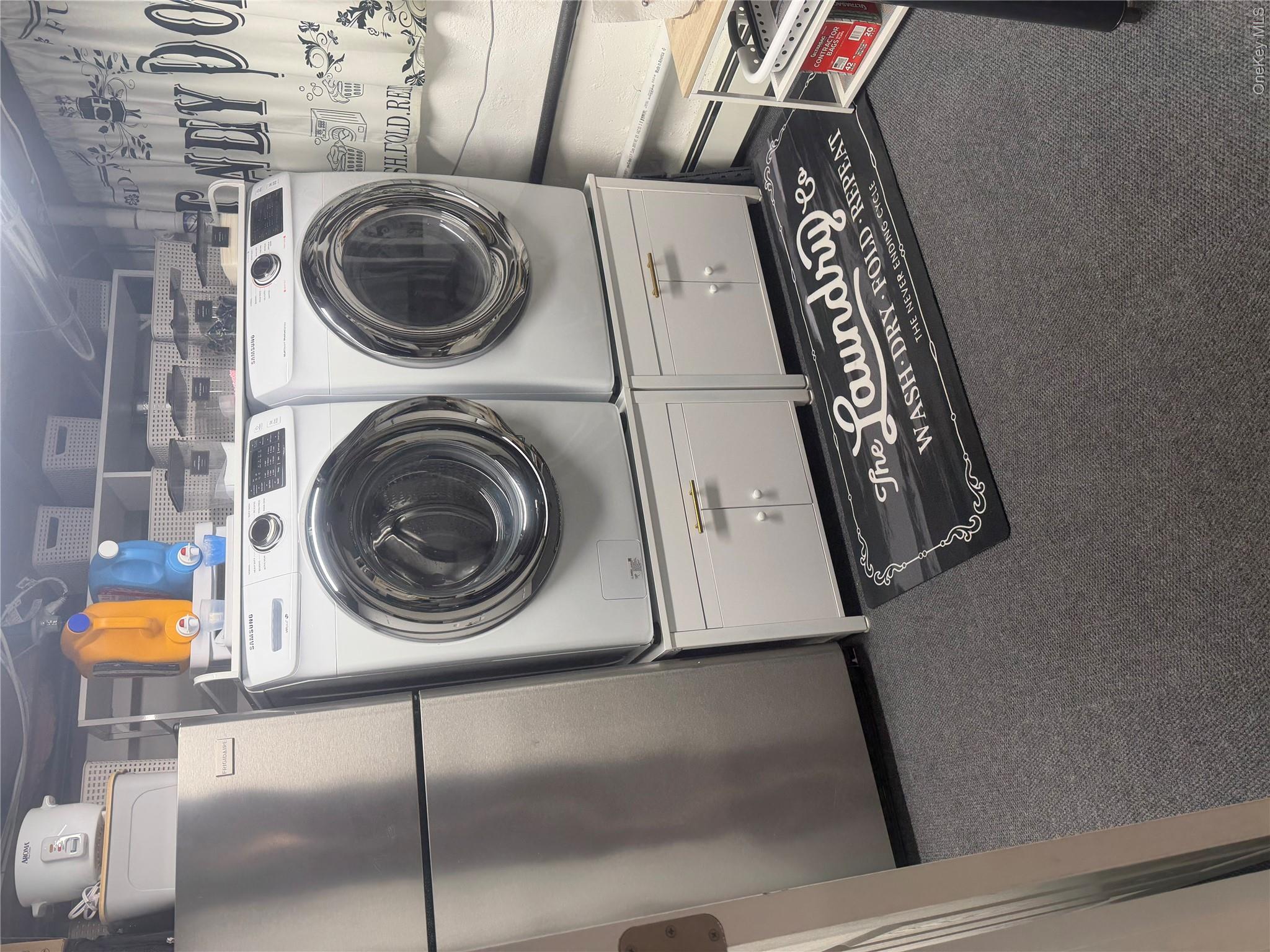 1580 North Jerusalem Road Merrick, NY 11566 - Photo 31 of 36 This property features a laundry area with a stainless steel refrigerator, white washer and dryer units, and dark gray carpeting