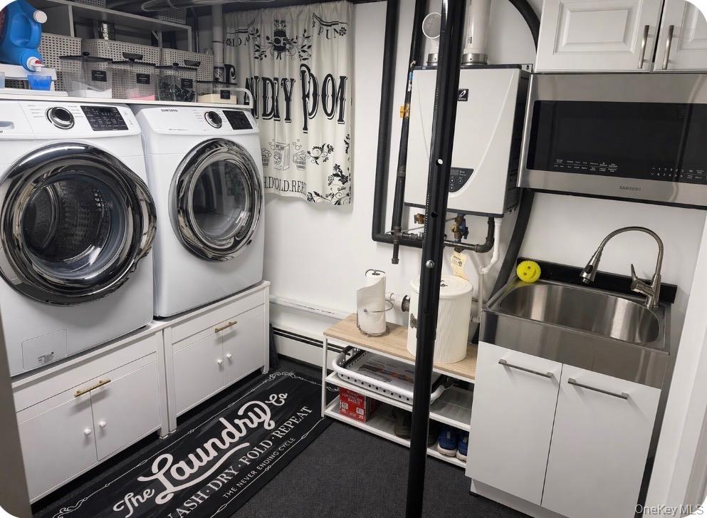 1580 North Jerusalem Road Merrick, NY 11566 - Photo 32 of 36 The property includes a dedicated laundry area featuring a white washing machine, white dryer, and white cabinetry