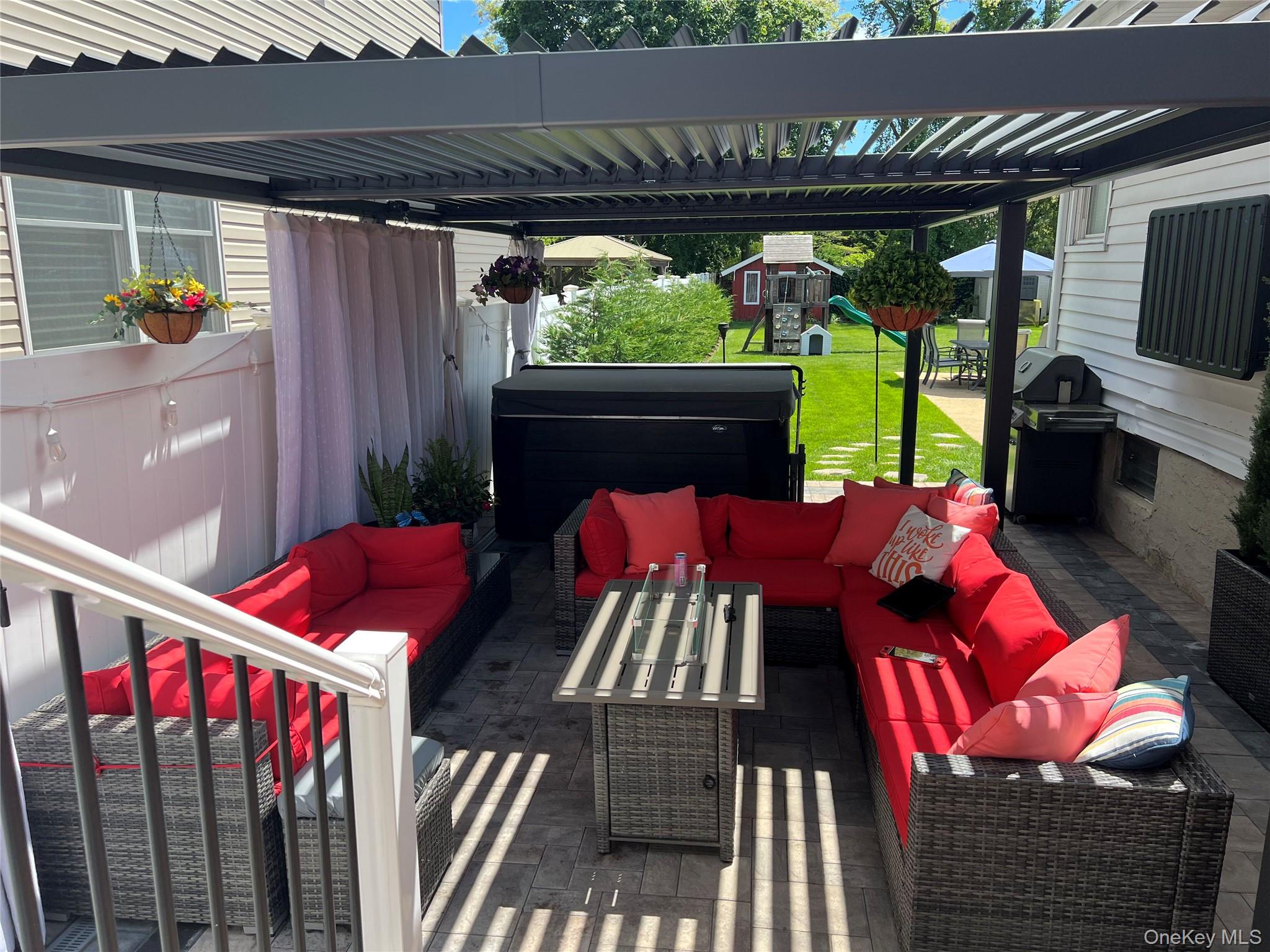 1580 North Jerusalem Road Merrick, NY 11566 - Photo 33 of 36 The property features a paved patio area with a pergola, offering a dedicated outdoor living space