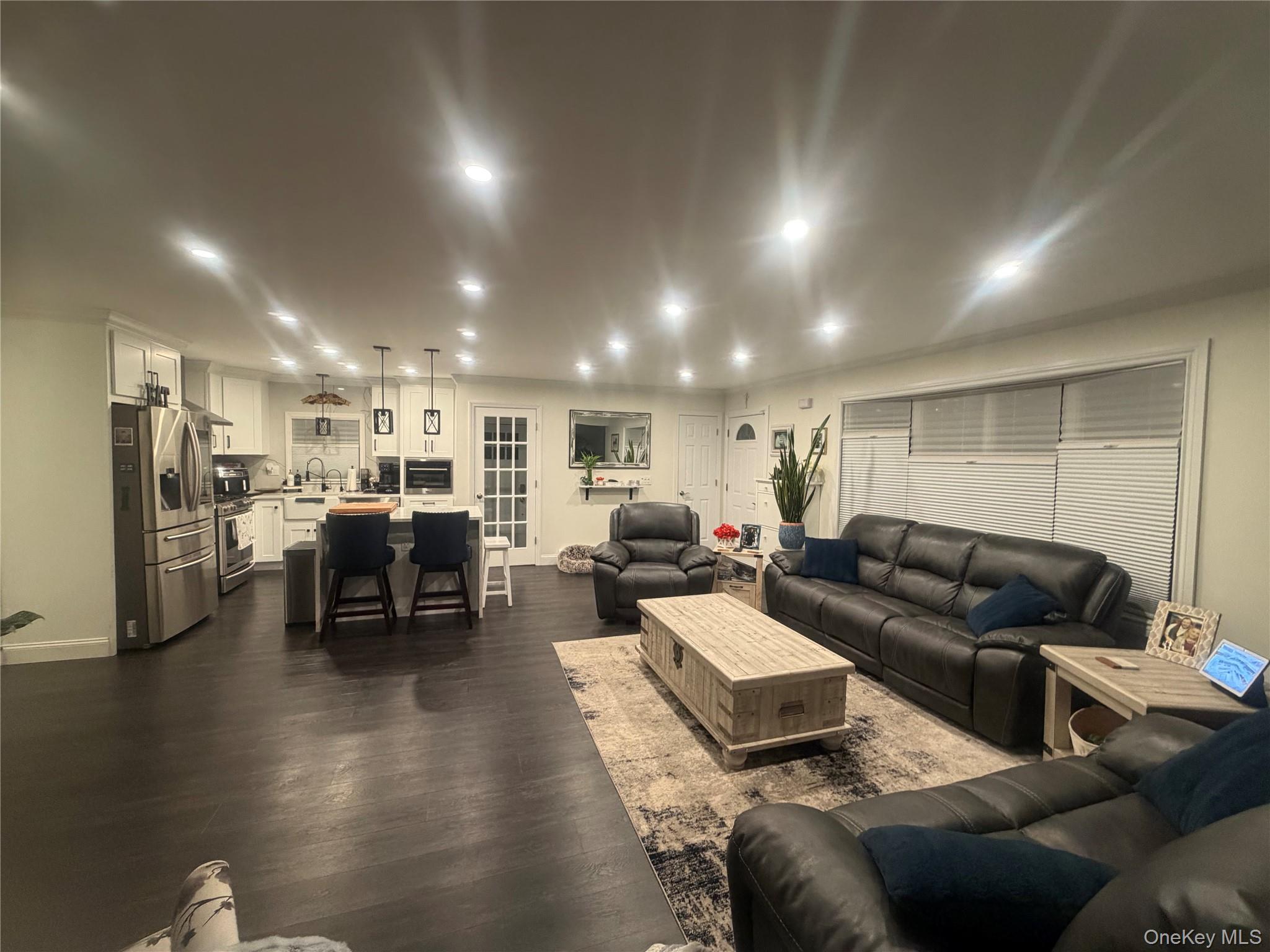 1580 North Jerusalem Road Merrick, NY 11566 - Photo 6 of 36 Open concept living space featuring dark wood flooring, recessed lighting, and a modern kitchen with stainless steel appliances