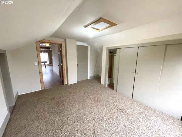 a view of a room with wooden floor and a window