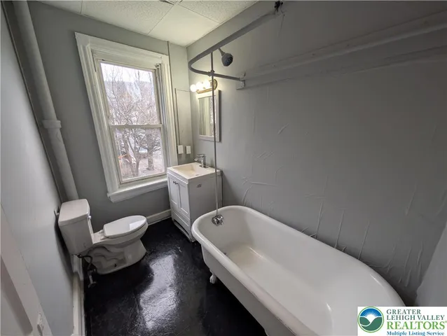 a spacious bathroom with a bathtub a sink and a toilet