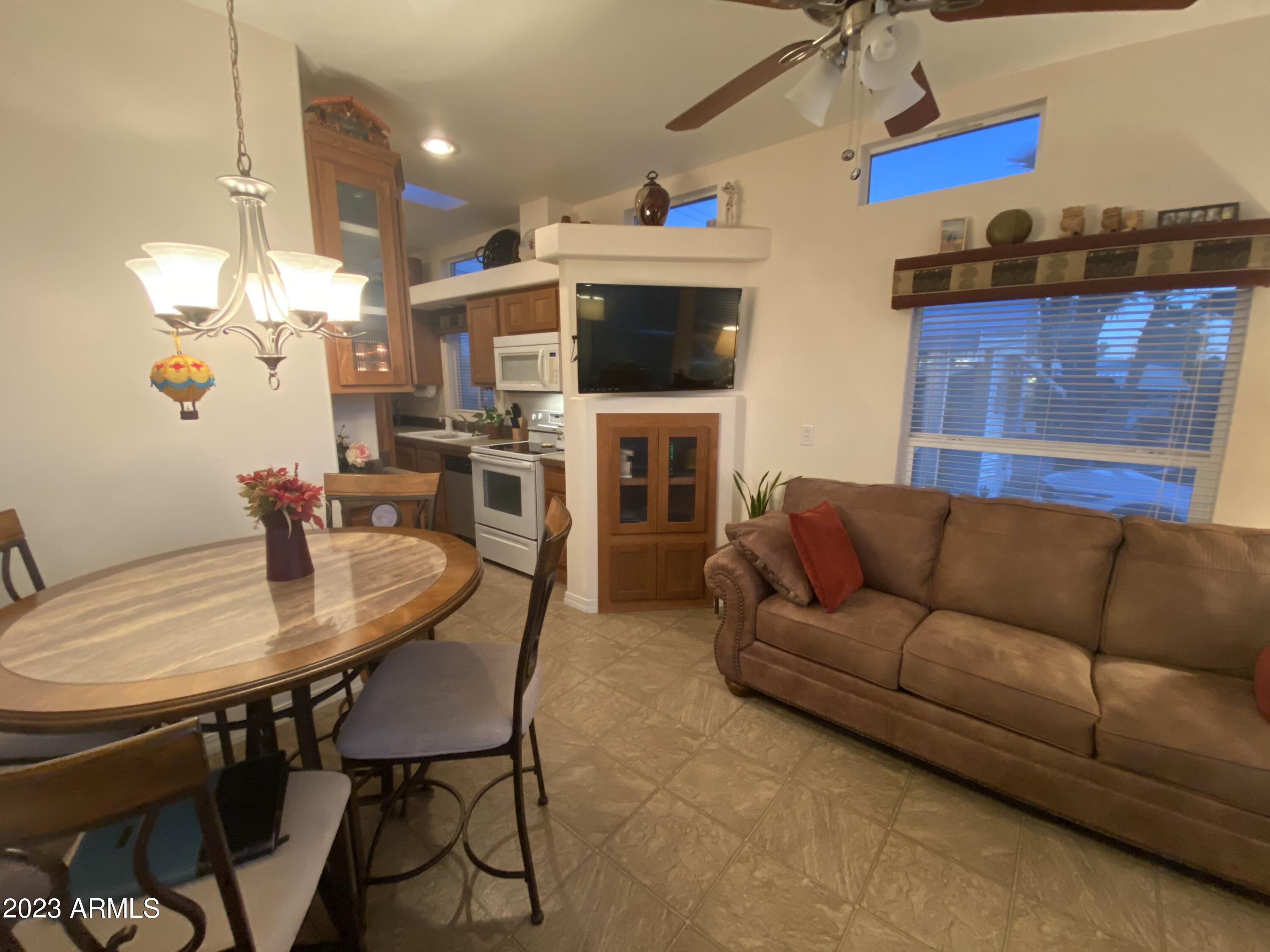 1358 Kiowa Circle, Unit 358 Apache Junction, AZ 85119 - Photo 4 of 37 a living room with furniture a flat screen tv and kitchen view