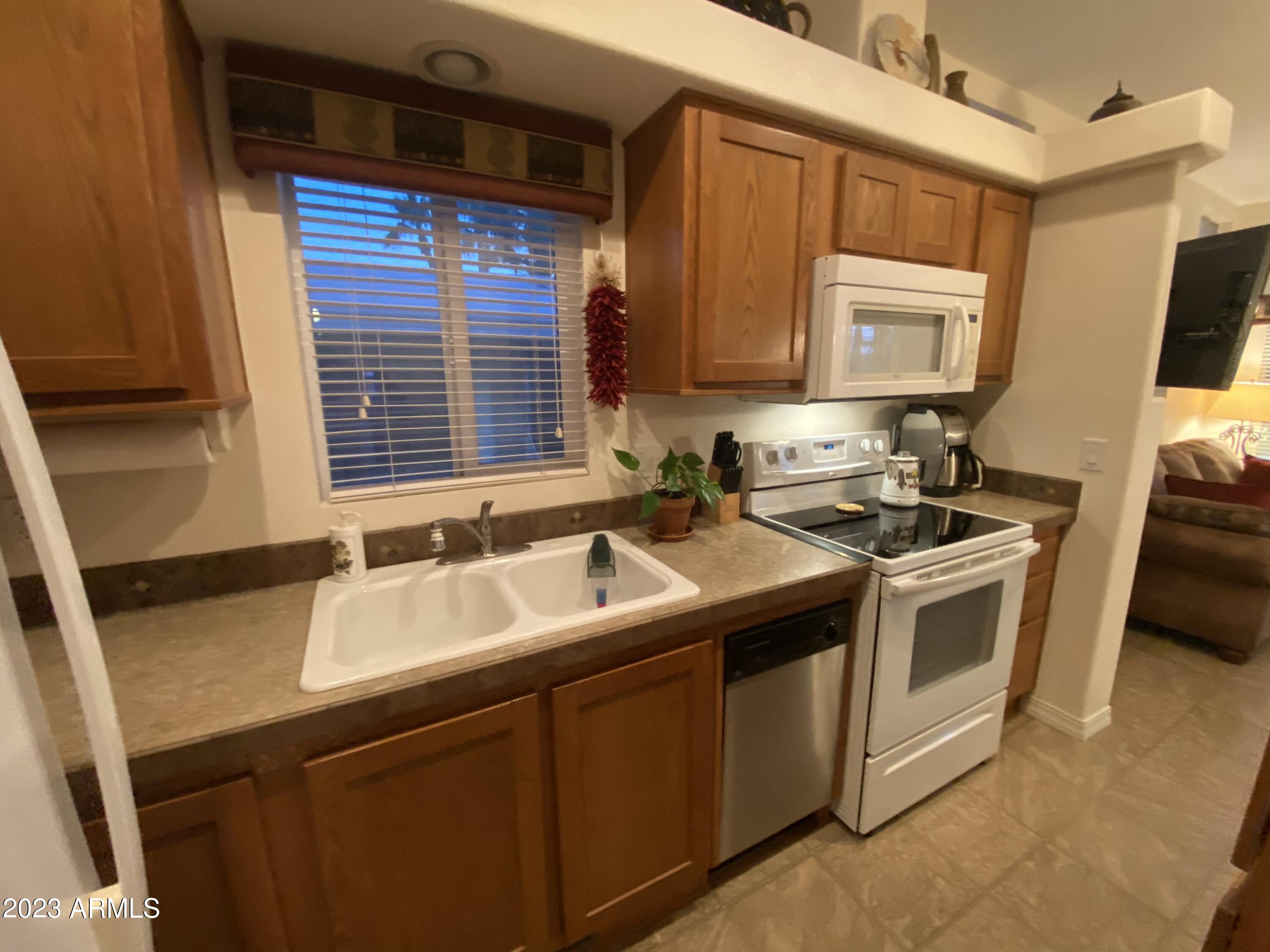 1358 Kiowa Circle, Unit 358 Apache Junction, AZ 85119 - Photo 8 of 37 a kitchen with a sink stove and cabinets