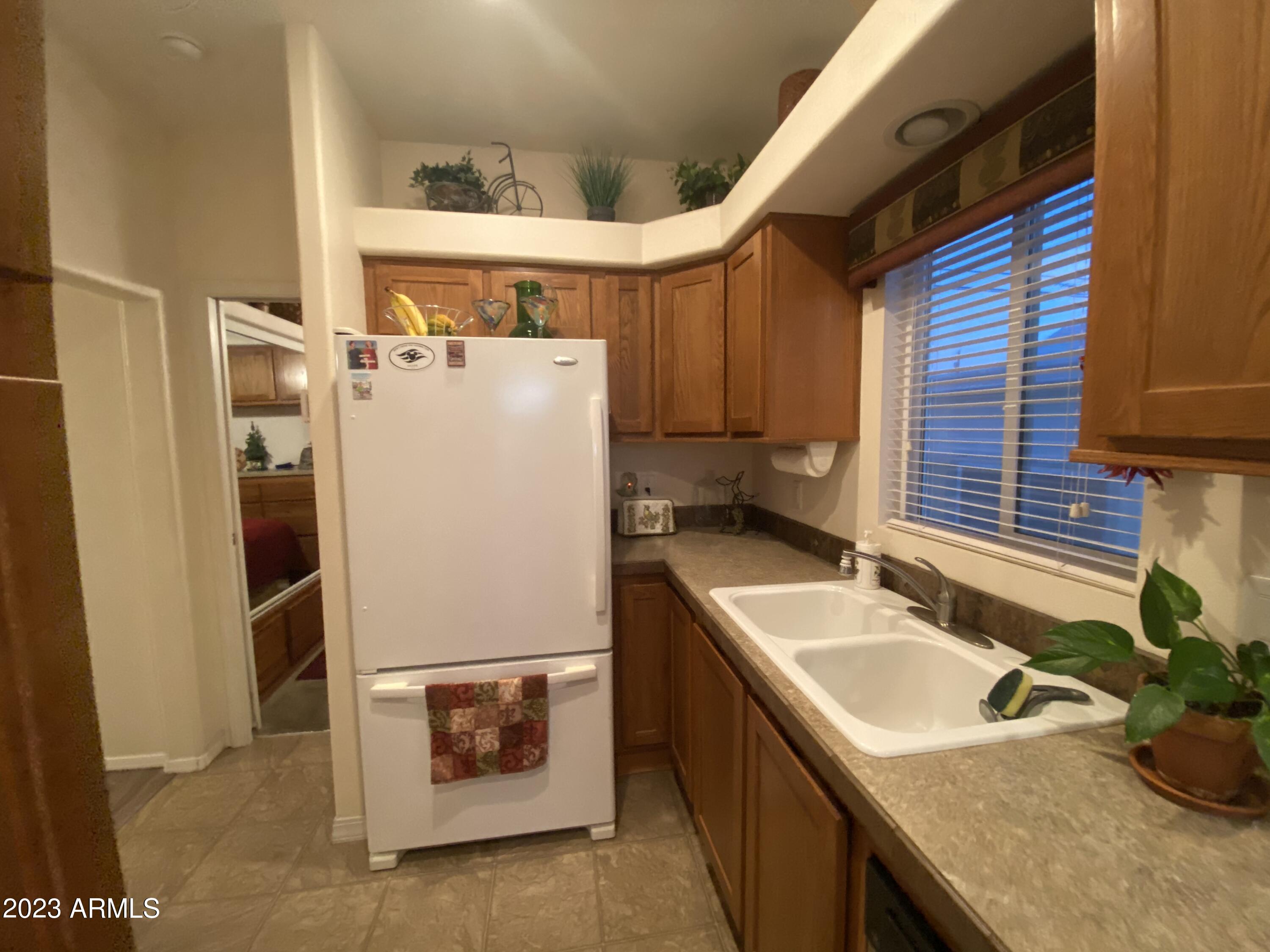 1358 Kiowa Circle, Unit 358 Apache Junction, AZ 85119 - Photo 9 of 37 a white refrigerator freezer sitting in a kitchen