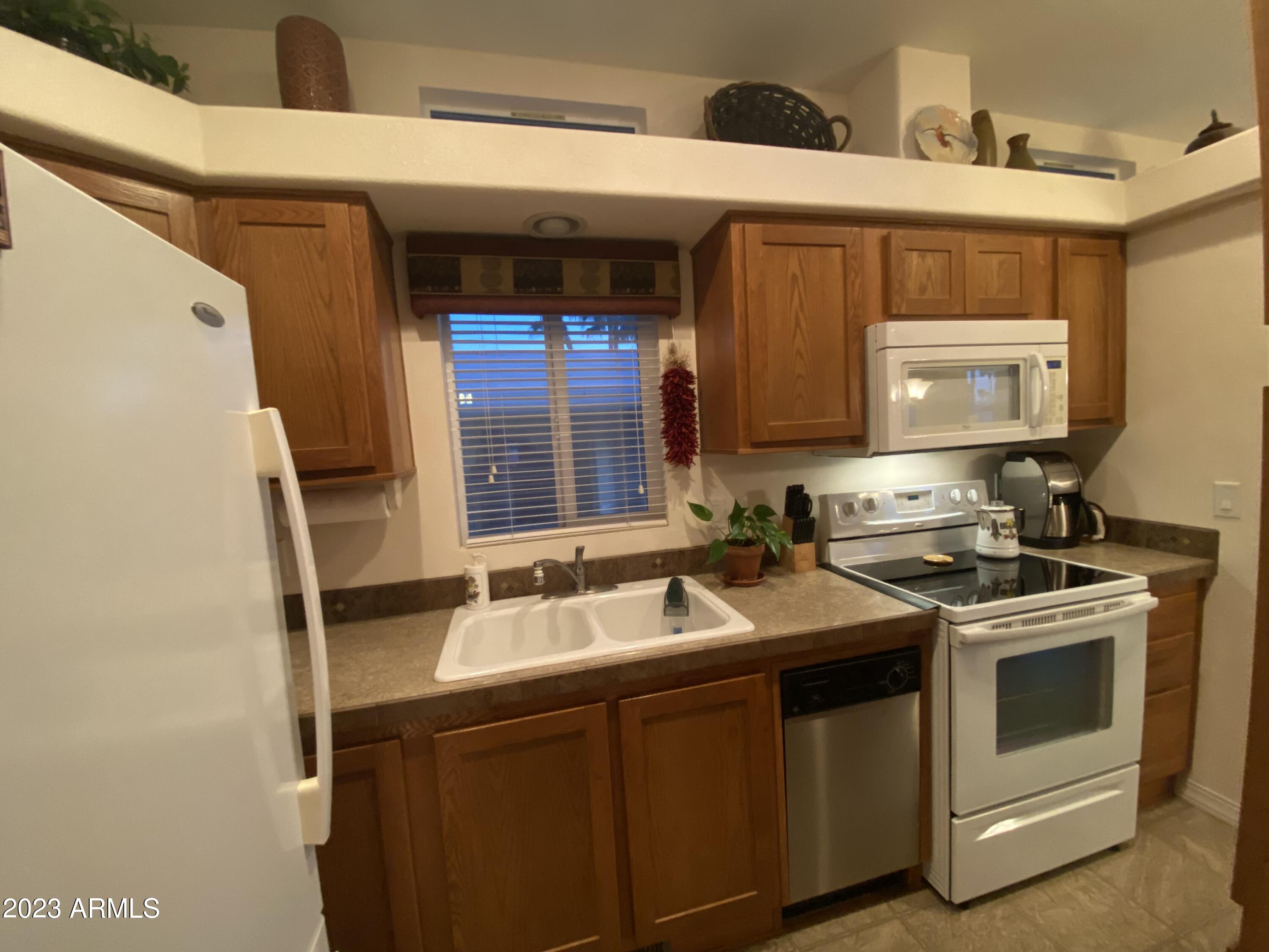1358 Kiowa Circle, Unit 358 Apache Junction, AZ 85119 - Photo 10 of 37 a kitchen with a sink stove and cabinets