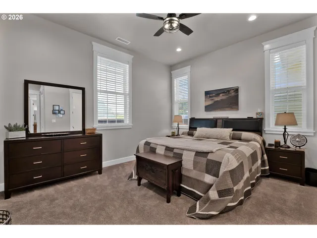 a spacious bedroom with a bed and a dresser