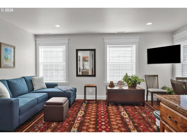 a living room with furniture a flat screen tv and a large window