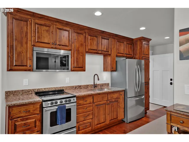 a kitchen with stainless steel appliances granite countertop a refrigerator stove and sink