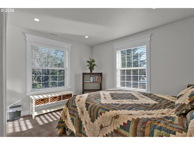 a bedroom with a bed and a large window