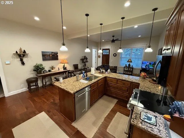 a large kitchen with kitchen island a stove a sink a center island and a wooden floor