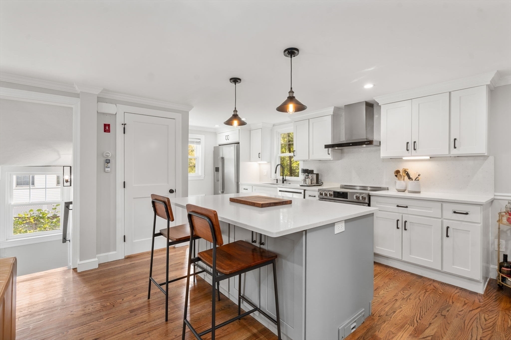 317 Dedham Avenue Needham, MA 02492 - Photo 11 of 29 a kitchen with stainless steel appliances granite countertop a sink a stove a refrigerator and island with wooden floor