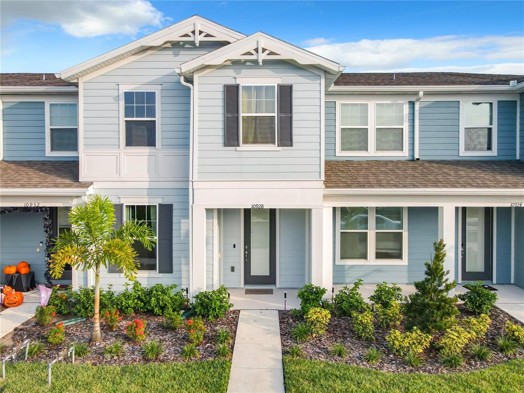 a front view of a house with plants and trees