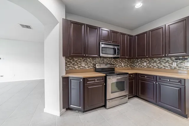 a kitchen with stainless steel appliances granite countertop a refrigerator stove and sink