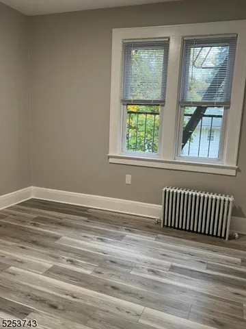 a view of a room with wooden floor and a window