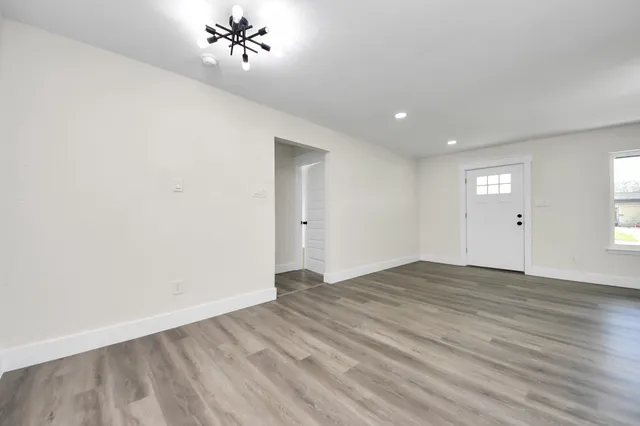 a large kitchen with stainless steel appliances kitchen island a stove a sink dishwasher and a refrigerator with wooden floor