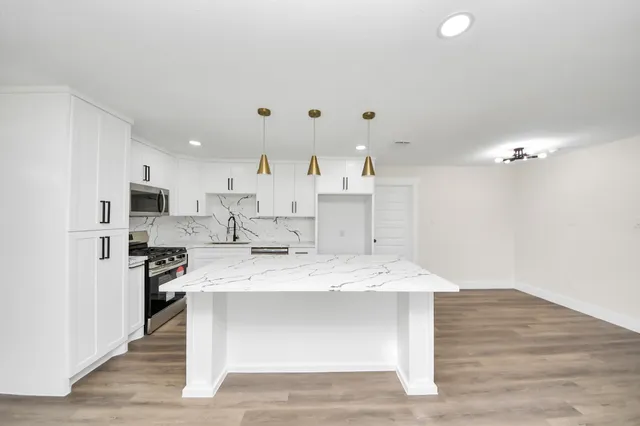 a view of kitchen with wooden floor and electronic appliances