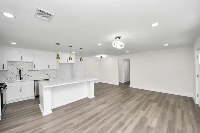a kitchen with a stove and wooden floor