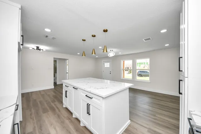 a spacious bathroom with a granite countertop sink a toilet and a bathtub