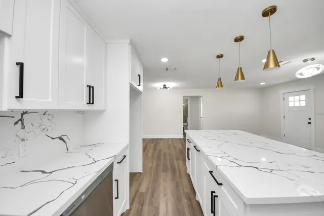 a kitchen with kitchen island a stove top oven a sink and a refrigerator