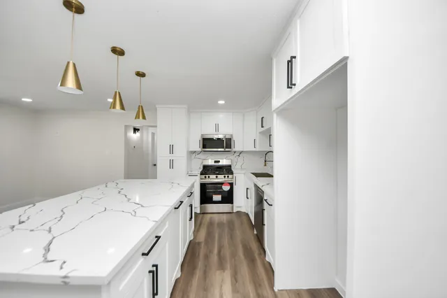 a bathroom with a toilet sink mirror and vanity