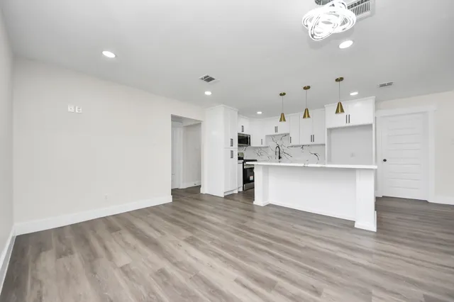 a view of an empty room with wooden floor