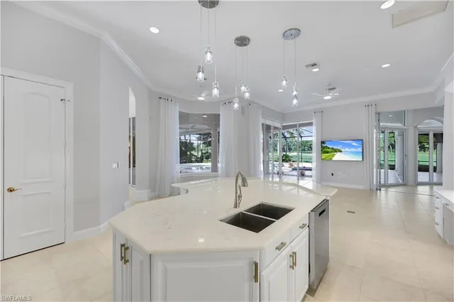 a large white kitchen with a large window and stainless steel appliances