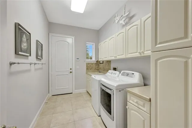 a utility room with cabinets washer and dryer