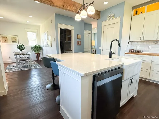 a kitchen with sink and view of living room