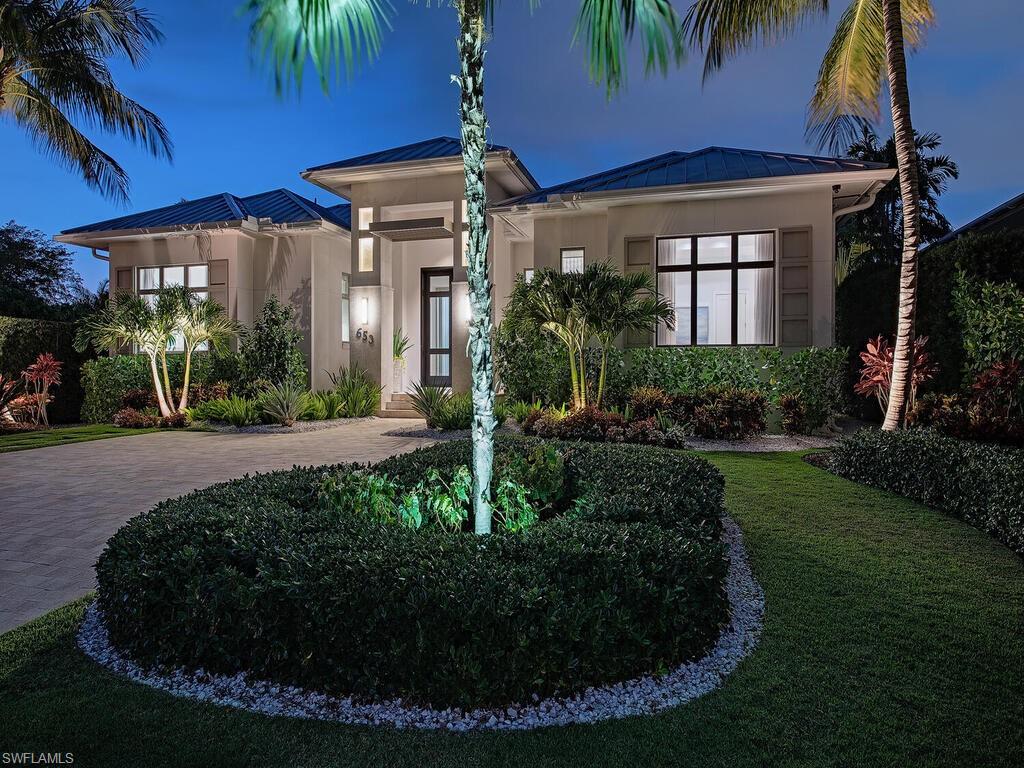 653 13th Avenue South Naples, FL 34102 - Photo 1 of 1 a view of a house with a small yard plants and palm trees