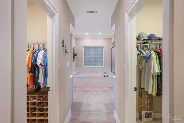 a view of walk in closet with clothes and shoes