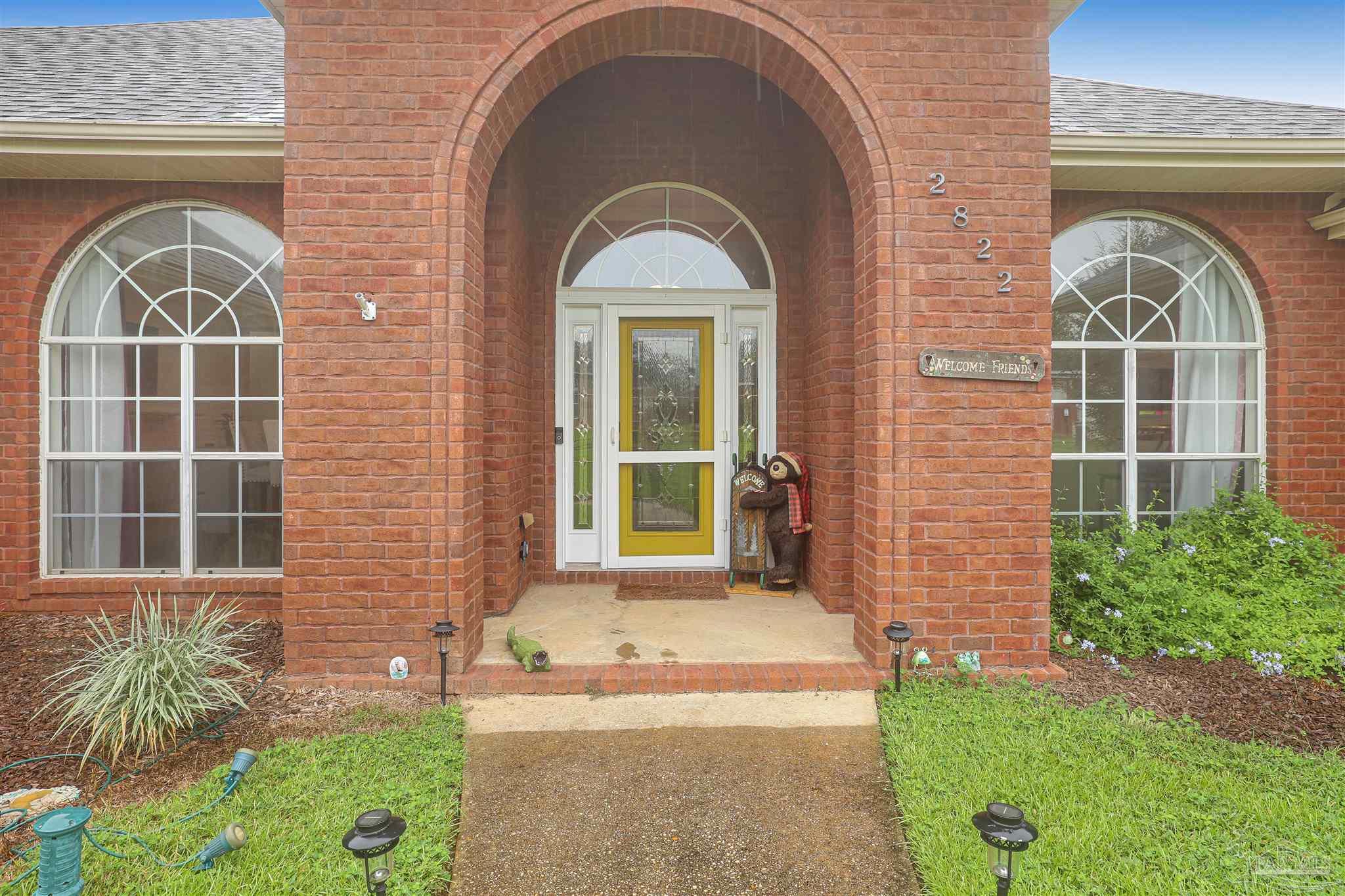 2822 Frederick Street Cantonment, FL 32533 - Photo 2 of 42 a front view of a house with a garden