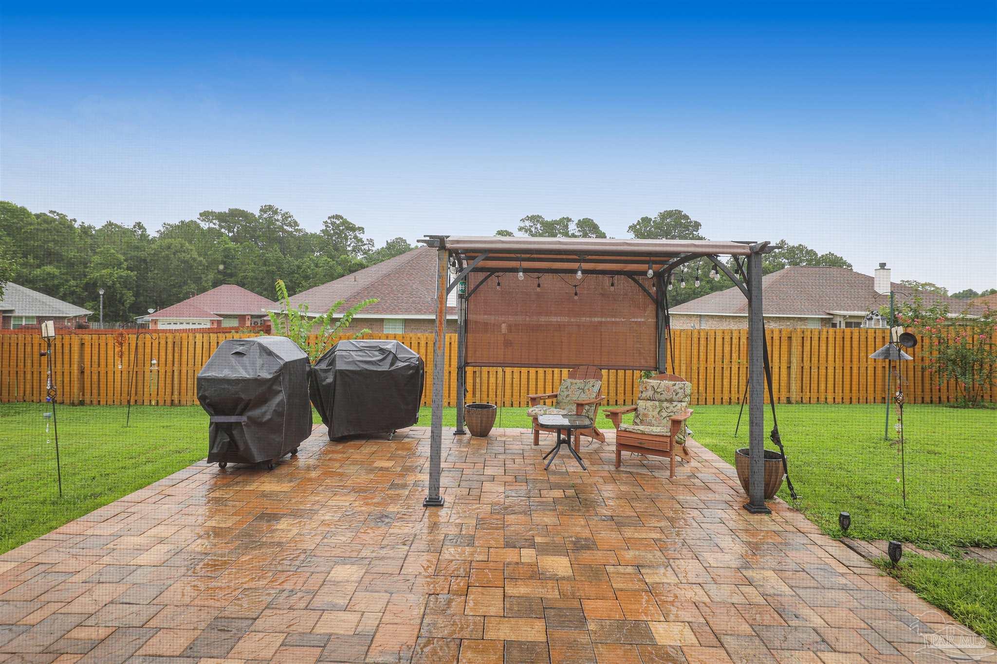 2822 Frederick Street Cantonment, FL 32533 - Photo 31 of 42 a view of a patio with a table and chairs under an umbrella