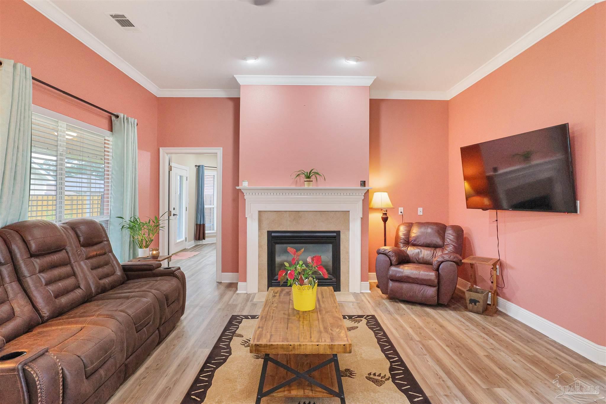 2822 Frederick Street Cantonment, FL 32533 - Photo 4 of 42 a living room with furniture a flat screen tv and a fireplace