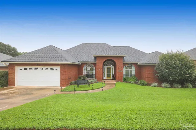 a front view of a house with a garden and yard