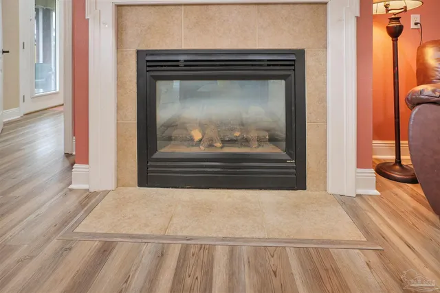 a view of a livingroom with wooden floor and a fireplace