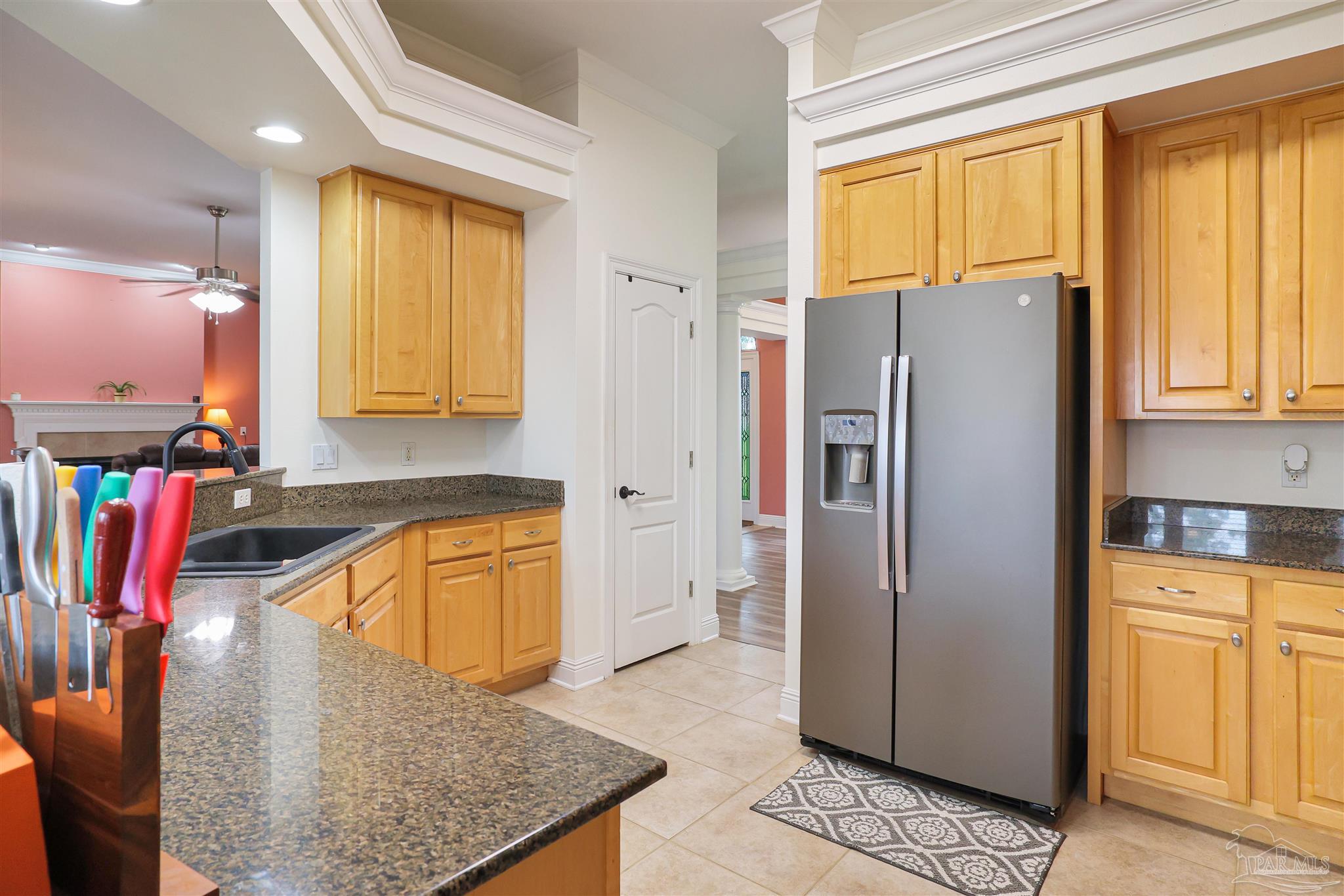 2822 Frederick Street Cantonment, FL 32533 - Photo 8 of 42 a kitchen with stainless steel appliances granite countertop a refrigerator a stove and a sink with wooden floor