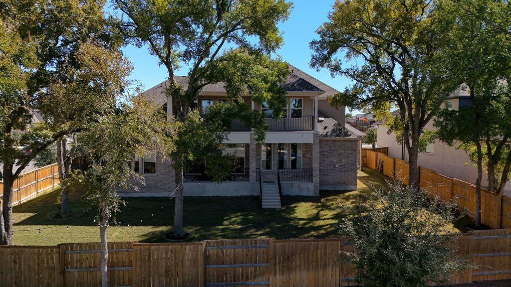 351 Pigeon River Road Kyle, TX 78640 - Photo 38 of 40 View of property exterior with a balcony, a fenced backyard, brick siding, and a patio area