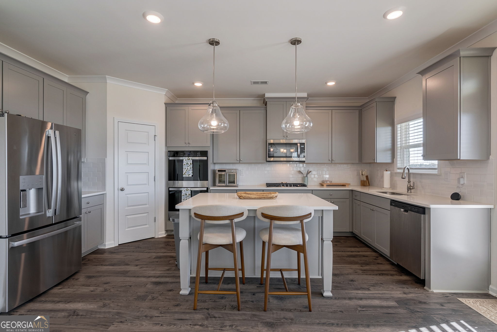 1110 Brookstone Crossing Statham, GA 30666 - Photo 3 of 69 a kitchen with stainless steel appliances granite countertop a table chairs sink refrigerator and microwave