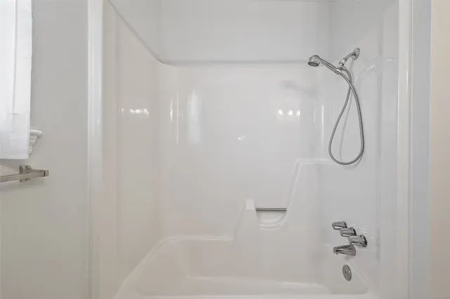 a bathroom with a bath tub with a shower