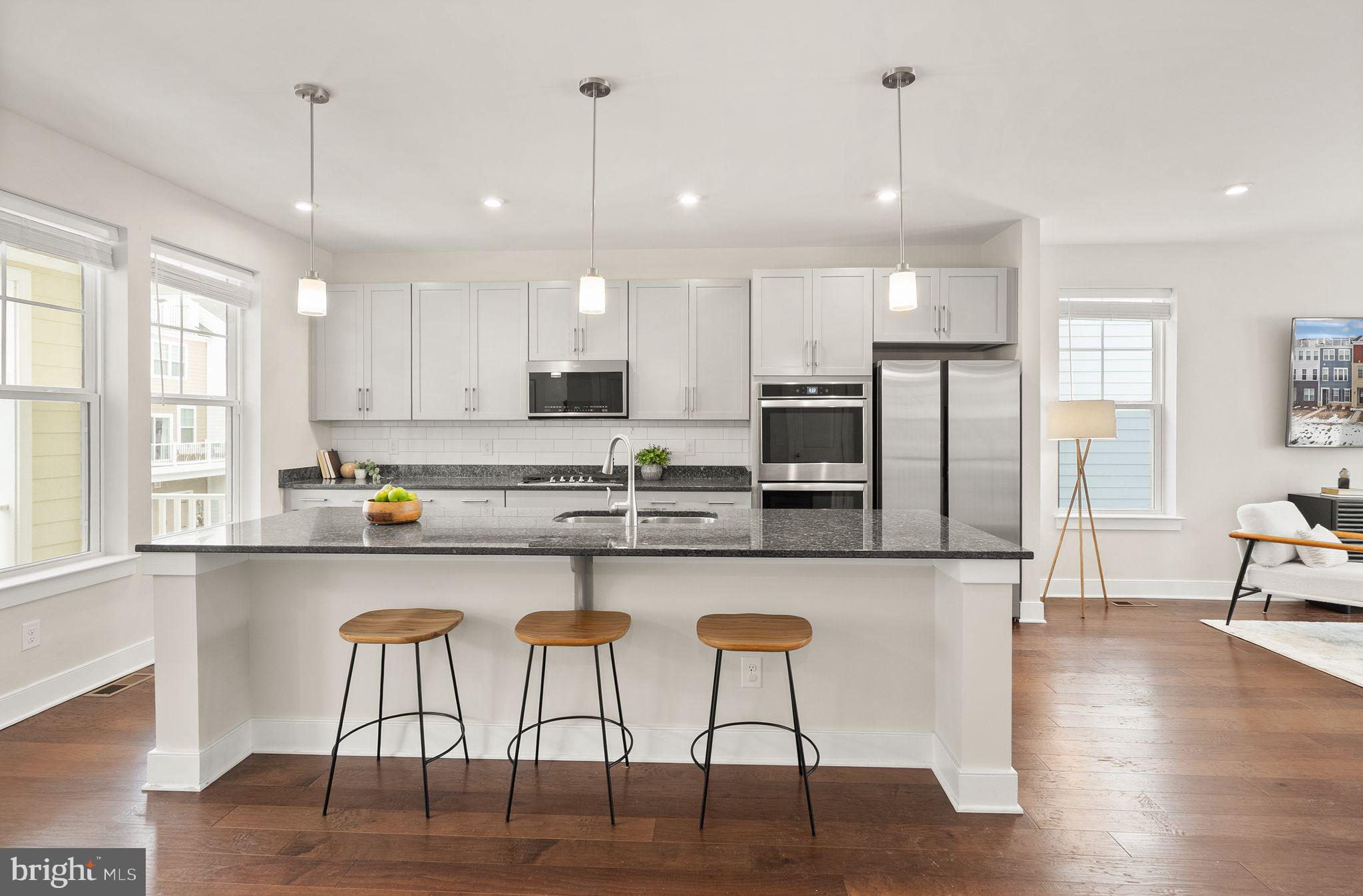 17762 Kingfisher Isle Road Dumfries, VA 22026 - Photo 6 of 62 a kitchen with stainless steel appliances granite countertop a stove top oven a refrigerator a sink and chairs