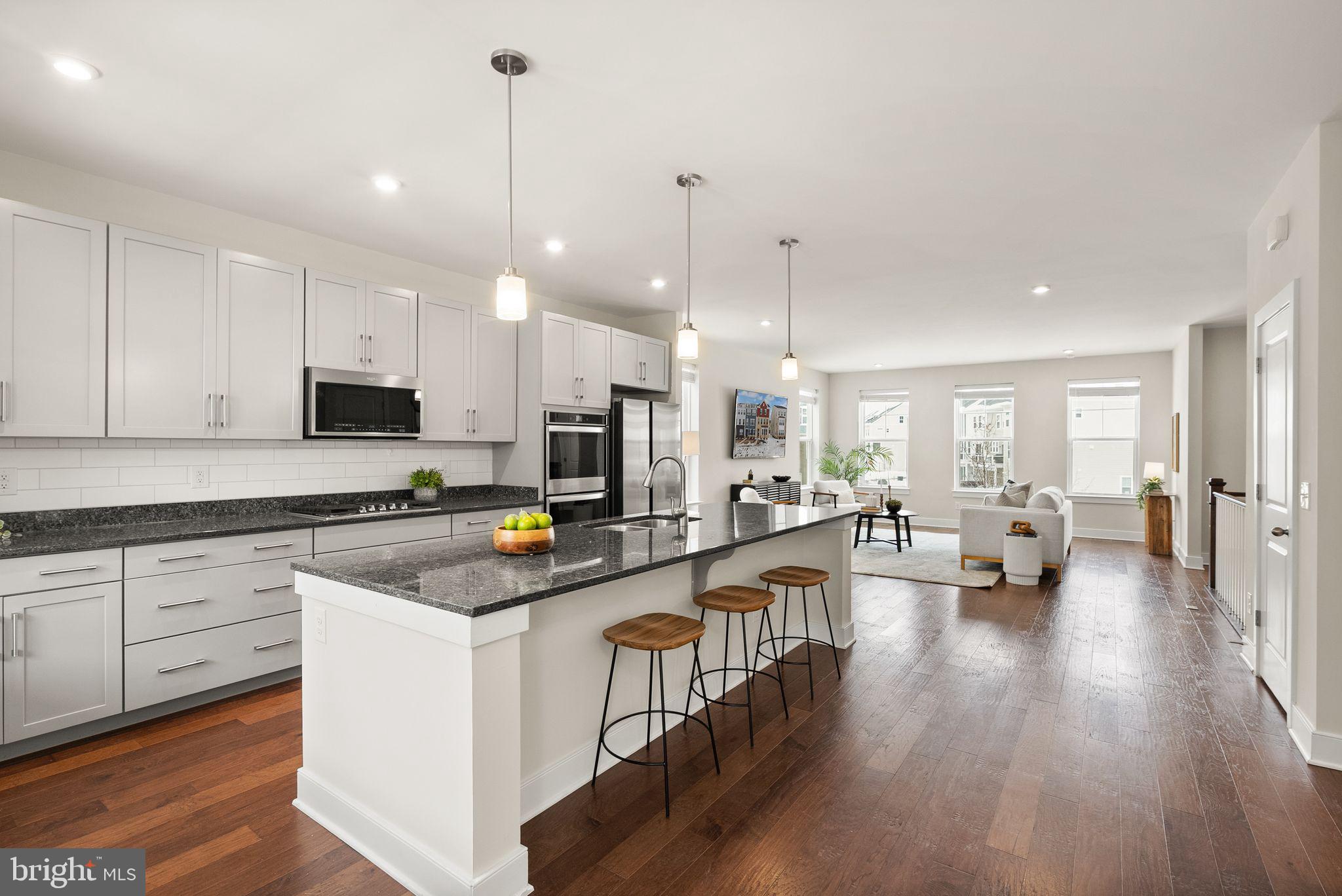 17762 Kingfisher Isle Road Dumfries, VA 22026 - Photo 8 of 62 a kitchen with sink stove and white cabinets with wooden floor