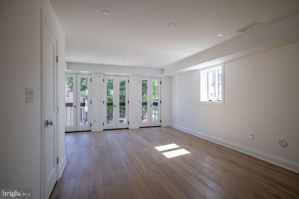 1202 Potomac Street Northwest Washington, DC 20007 - Photo 12 of 37 a view of an empty room with wooden floor and a window