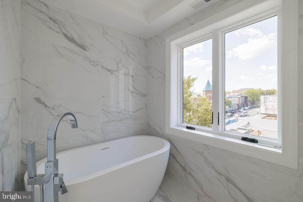 1202 Potomac Street Northwest Washington, DC 20007 - Photo 24 of 37 a white bath tub sitting in a bathroom next to a window