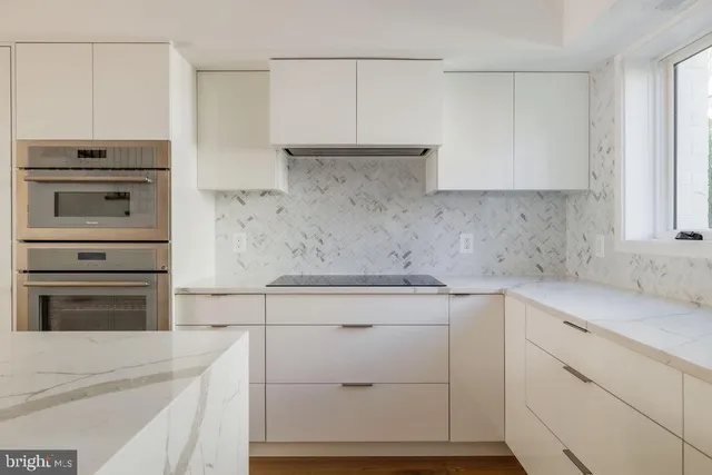 a kitchen with white cabinets and white appliances