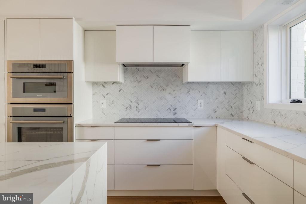 1202 Potomac Street Northwest Washington, DC 20007 - Photo 6 of 37 a kitchen with white cabinets and white appliances